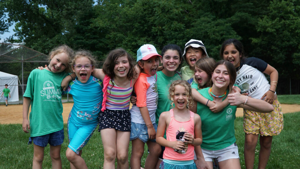 Group of girl campers smiling outside.