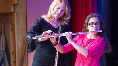 Teacher giving flute lesson to a young girl.