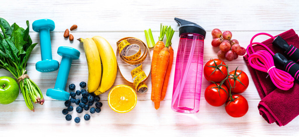 Colorful assortment of health food and water bottles and workout gear.