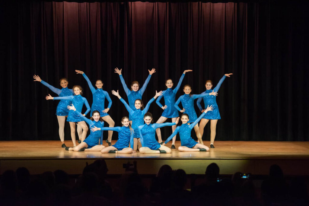 Dance performance on stage all in blue leotards.