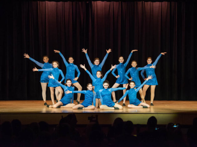Dance performance on stage all in blue leotards.