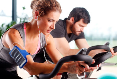 Two people on exercise bikes.