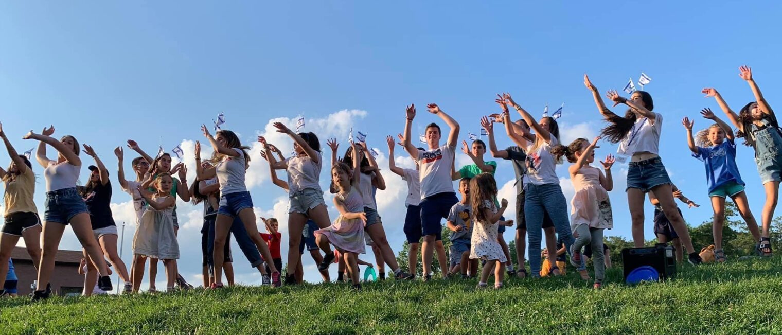 Children smiling doing group activities on a hill.