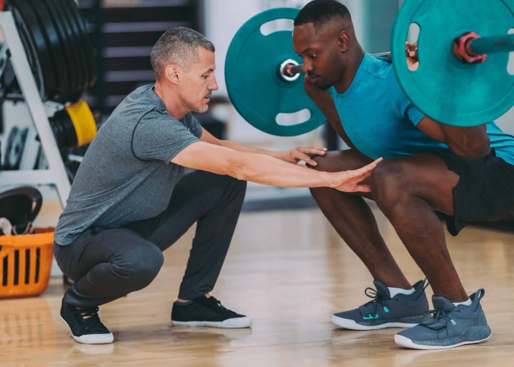 Personal trainer at Kaplen JCC on the Palisades assisting a member with weightlifting.