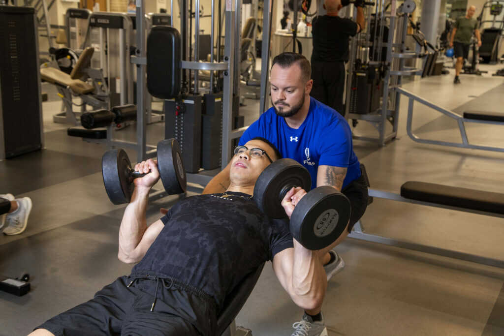 Personal Trainer spotting member at Kaplen JCC on the Palisades