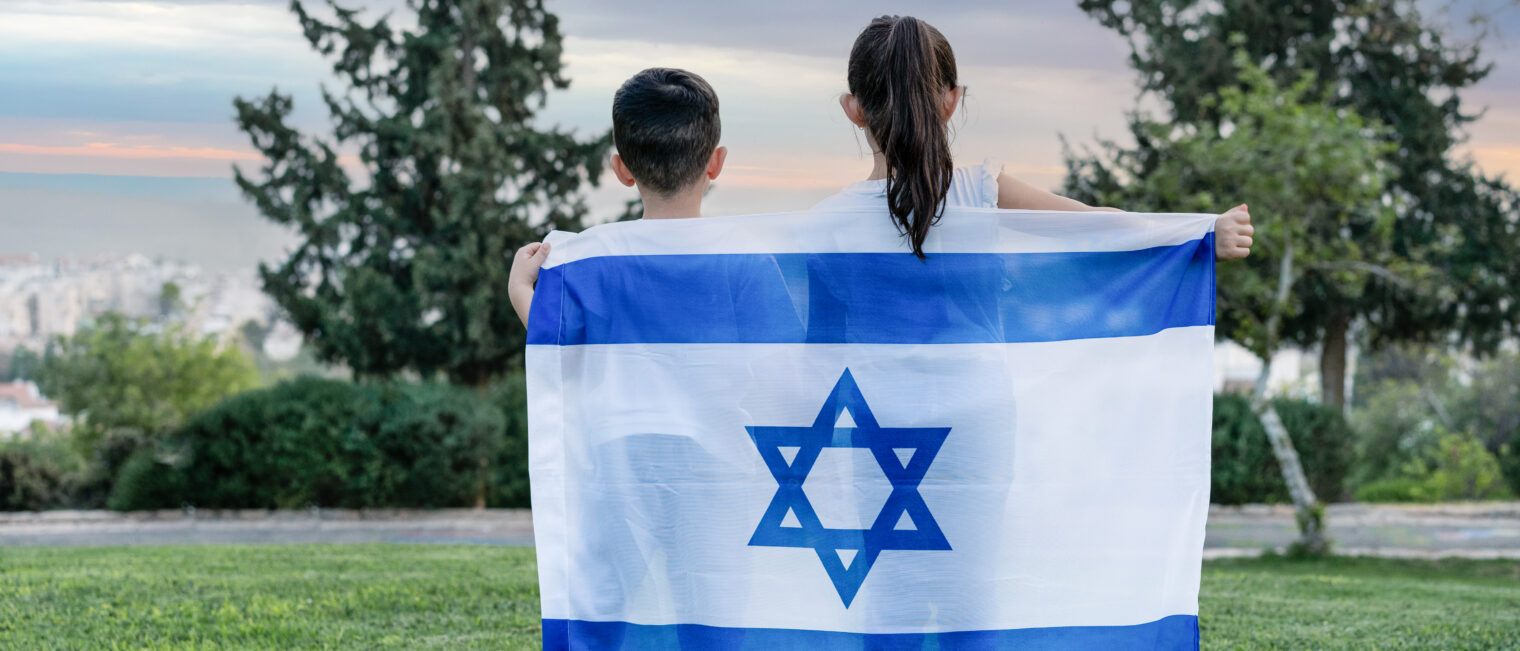 Children holding the Israeli flag, representing Israeli & Jewish Life at Kaplen JCC